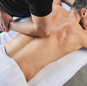 homem deitado recebendo massagem desportiva nas costas
