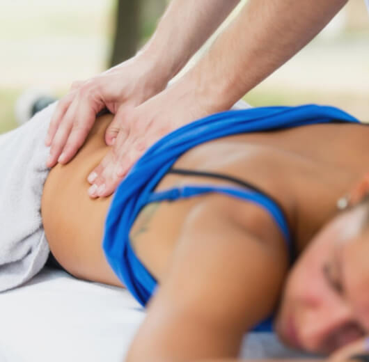 Mulher com roupa esportiva recebendo massagem nas costas
