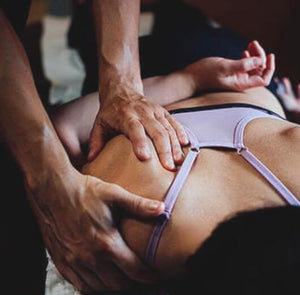 Mulher recebendo massagem desportiva após o treino