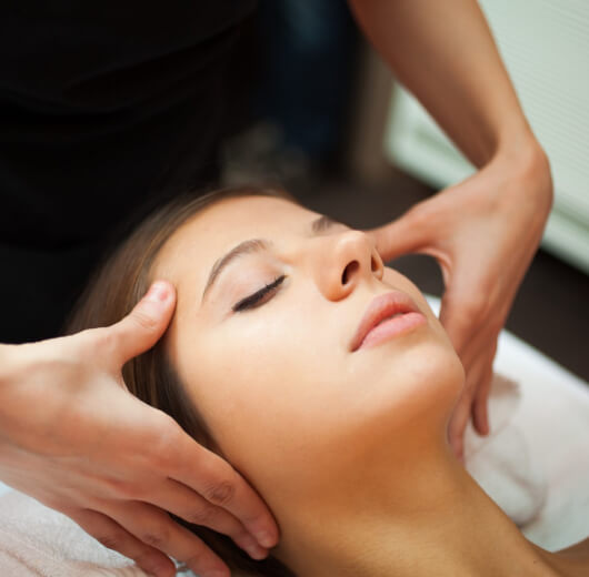 Mulher recebendo massagem relaxante na cabeça