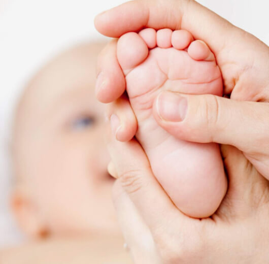 bebê recebendo shantala no pé