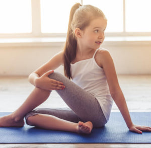 criança fazendo torção de yoga