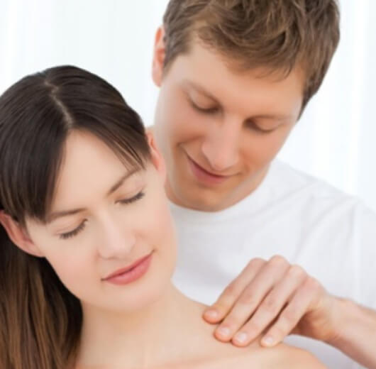 homem fazendo massagem no ombro da parceira