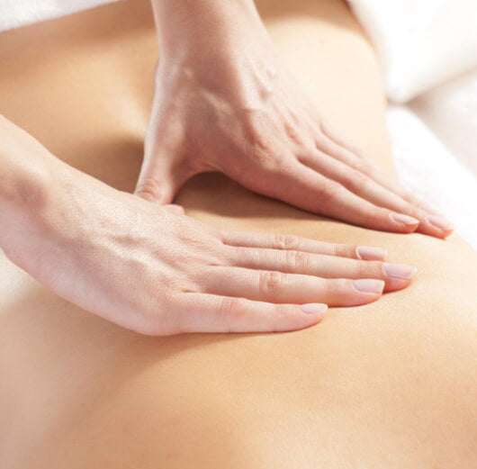 mulher recebendo massagem relaxante na lombar