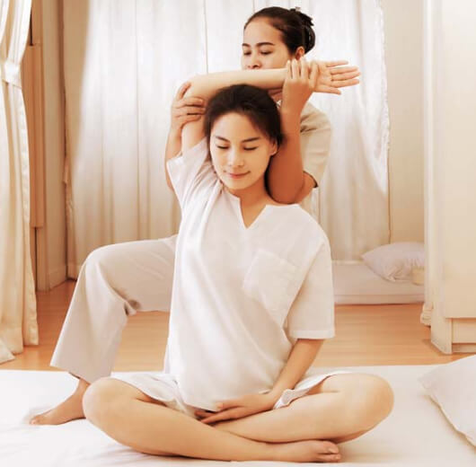 mulher se alongando durante thai massage