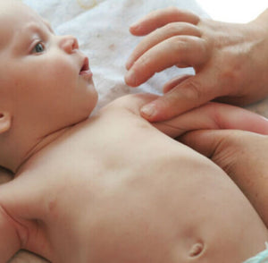 terapeuta fazendo shantala no braço de bebê
